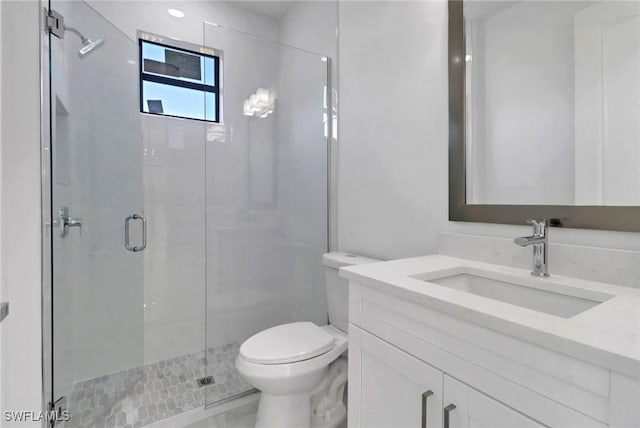 bathroom with an enclosed shower, vanity, and toilet