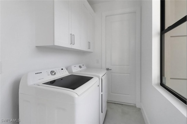 washroom featuring washing machine and dryer and cabinets