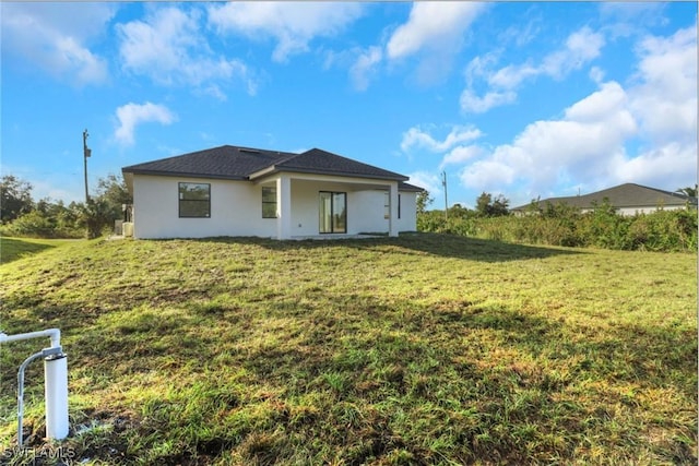 rear view of property featuring a yard