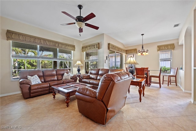 living room with ceiling fan with notable chandelier and light tile patterned floors