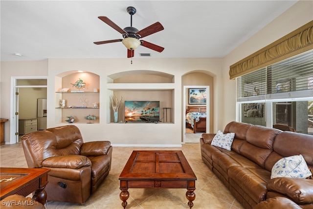 tiled living room featuring built in features and ceiling fan