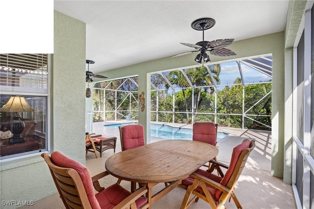 sunroom featuring a swimming pool and ceiling fan