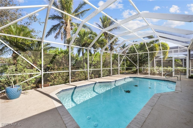 view of swimming pool featuring a patio and a lanai