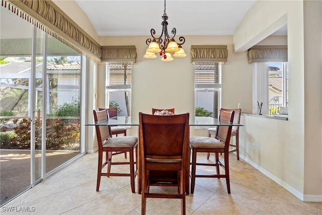 tiled dining space featuring lofted ceiling and a chandelier