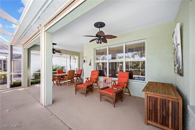 view of patio with glass enclosure and ceiling fan