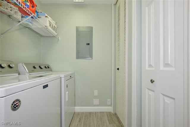 laundry room with electric panel, light hardwood / wood-style flooring, and separate washer and dryer