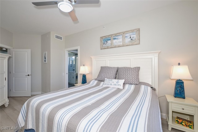 bedroom featuring ceiling fan, light hardwood / wood-style floors, and ensuite bath