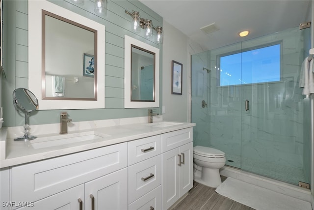 bathroom featuring vanity, toilet, walk in shower, and hardwood / wood-style floors