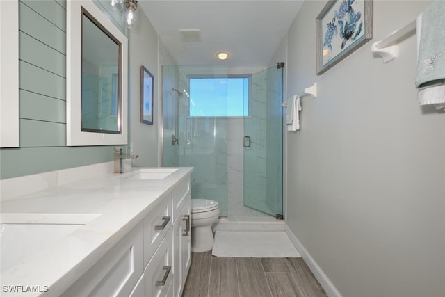 bathroom with a shower with door, toilet, and vanity