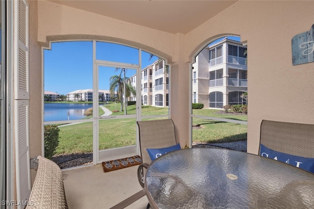 sunroom featuring a water view