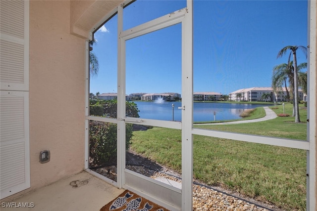 sunroom featuring a water view