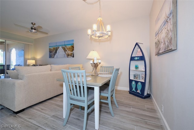 dining room featuring light hardwood / wood-style floors and ceiling fan with notable chandelier