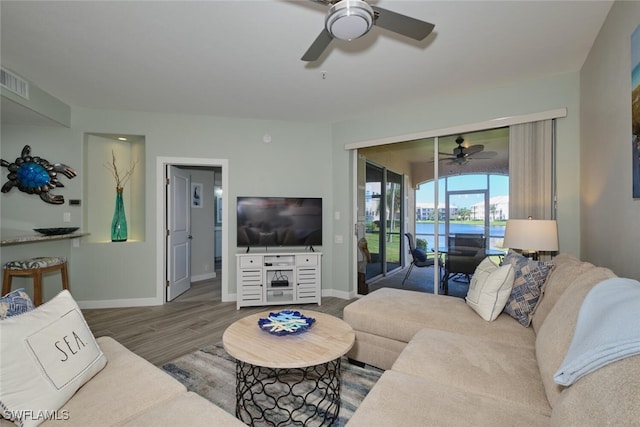 living room featuring wood-type flooring and ceiling fan