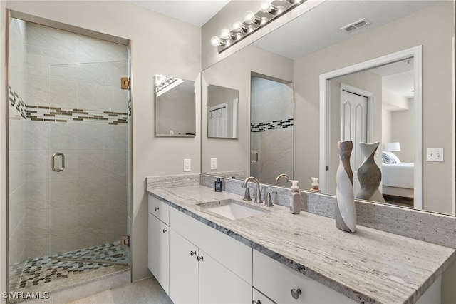 bathroom featuring a shower with door and vanity