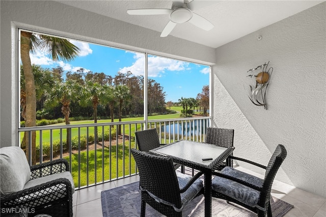 sunroom with a water view and ceiling fan