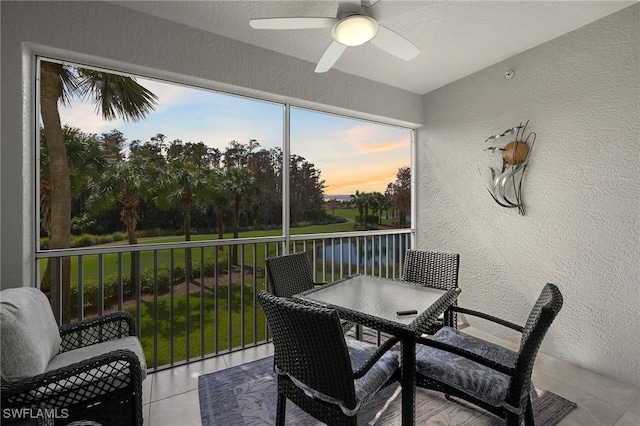 sunroom / solarium featuring a water view and ceiling fan