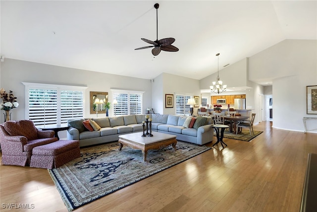 living room featuring high vaulted ceiling, wood-type flooring, and ceiling fan with notable chandelier