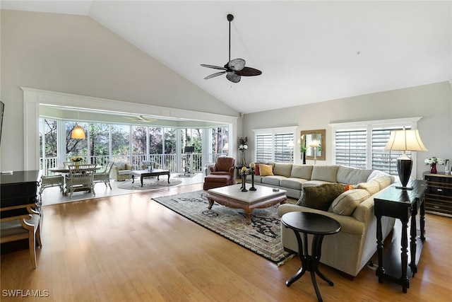 living room featuring ceiling fan, light wood-type flooring, and high vaulted ceiling