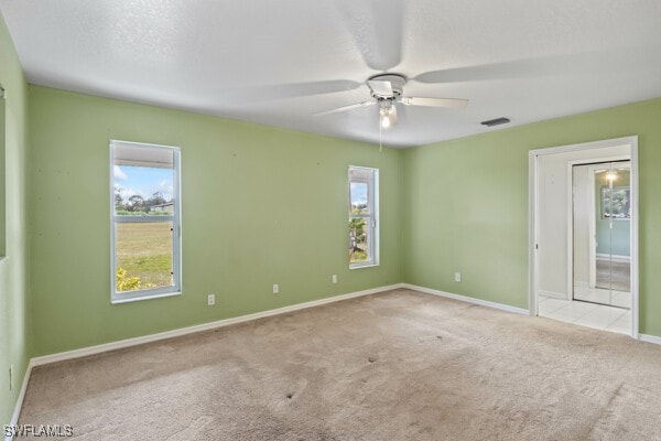 carpeted spare room featuring ceiling fan