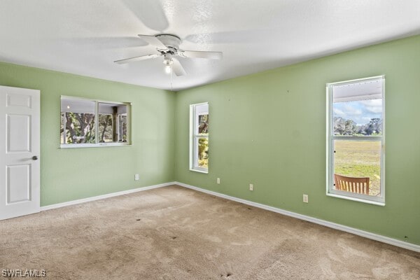 unfurnished room with ceiling fan and light colored carpet