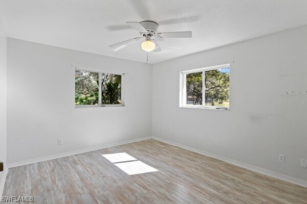 empty room with light hardwood / wood-style flooring, a wealth of natural light, and ceiling fan