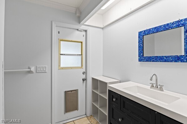 bathroom featuring tile patterned floors, vanity, and ornamental molding