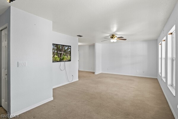 carpeted spare room with ceiling fan