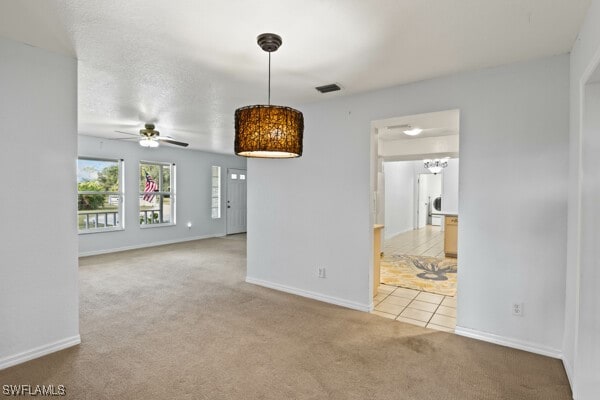 spare room with ceiling fan and light colored carpet