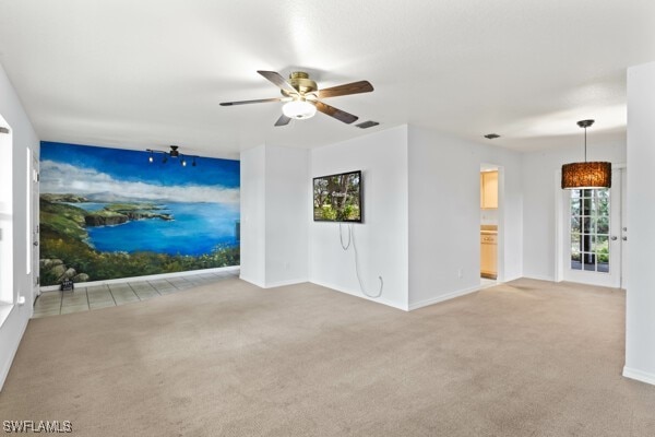 unfurnished living room with light carpet and ceiling fan