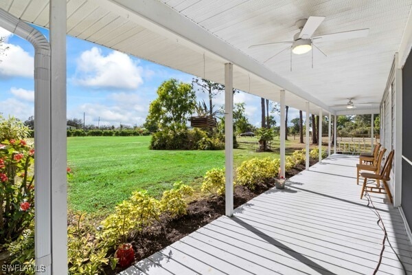 exterior space featuring a lawn, ceiling fan, and covered porch