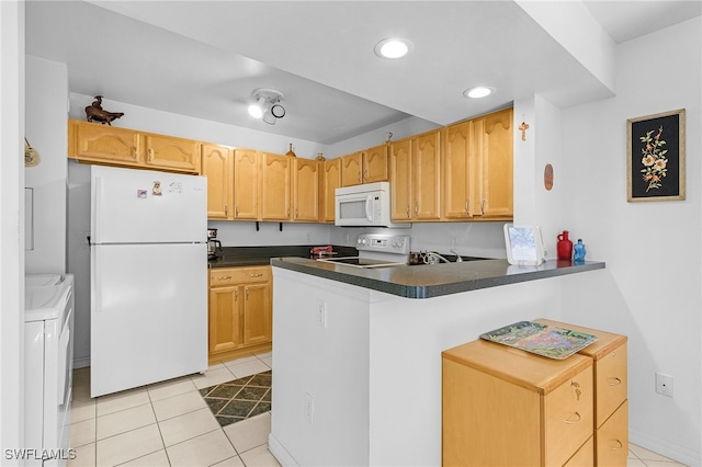 kitchen featuring white appliances, kitchen peninsula, light tile patterned floors, and separate washer and dryer