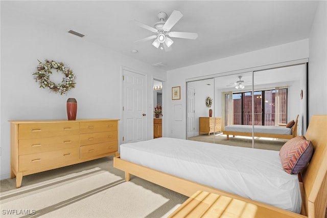 bedroom featuring ceiling fan, a closet, and light colored carpet