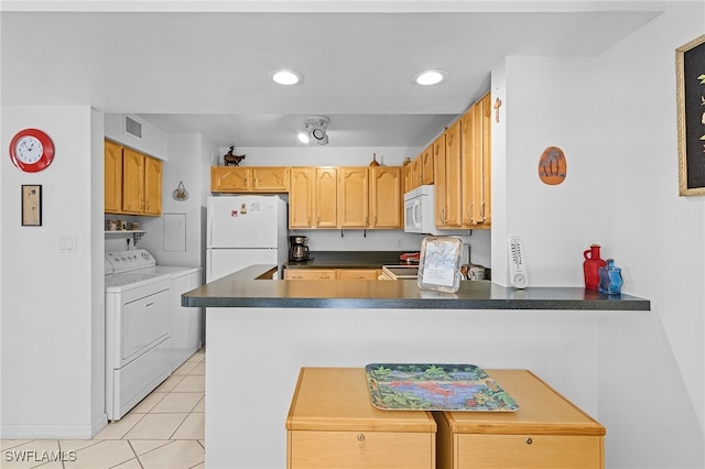 kitchen featuring white appliances, kitchen peninsula, light tile patterned floors, and washing machine and clothes dryer