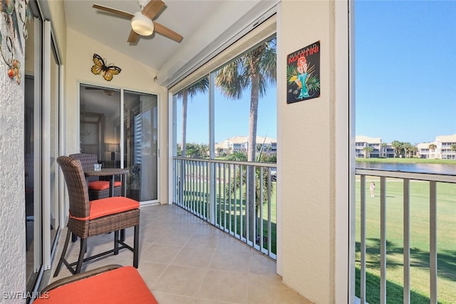 balcony featuring a water view and ceiling fan