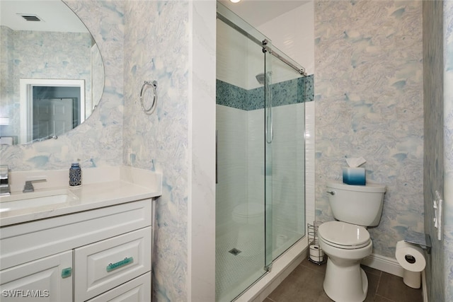 bathroom featuring vanity, tile patterned flooring, toilet, and an enclosed shower