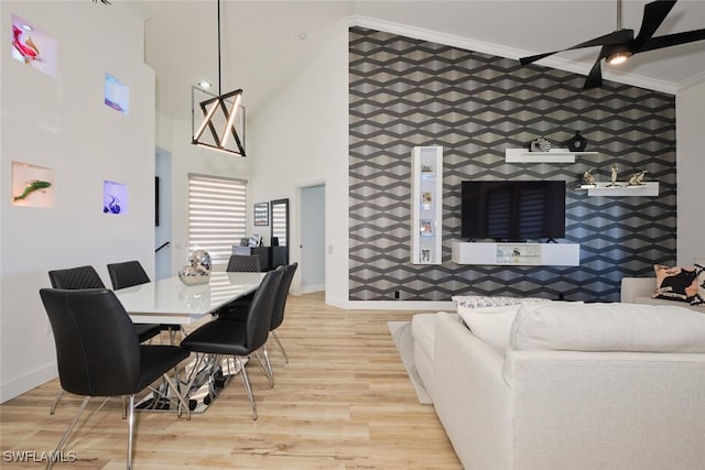 dining area with a high ceiling, wood-type flooring, crown molding, tile walls, and ceiling fan