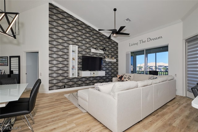 living room featuring ornamental molding, light hardwood / wood-style flooring, and ceiling fan