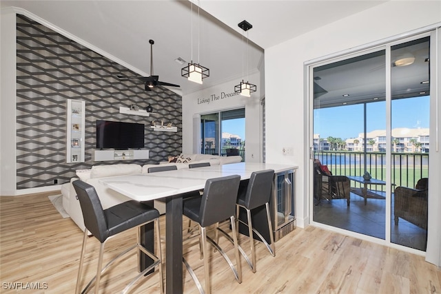 dining space with light hardwood / wood-style flooring, tile walls, and ceiling fan