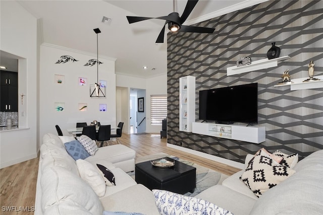 living room featuring ceiling fan, ornamental molding, and hardwood / wood-style floors