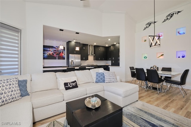 living room with light hardwood / wood-style flooring and a high ceiling