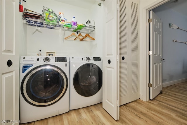 laundry area with light hardwood / wood-style flooring and separate washer and dryer