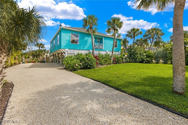 coastal home with a front lawn and a carport