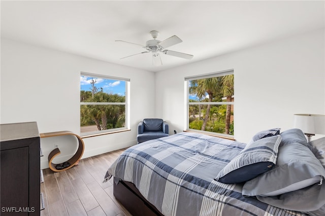 bedroom with multiple windows, light wood-type flooring, and ceiling fan