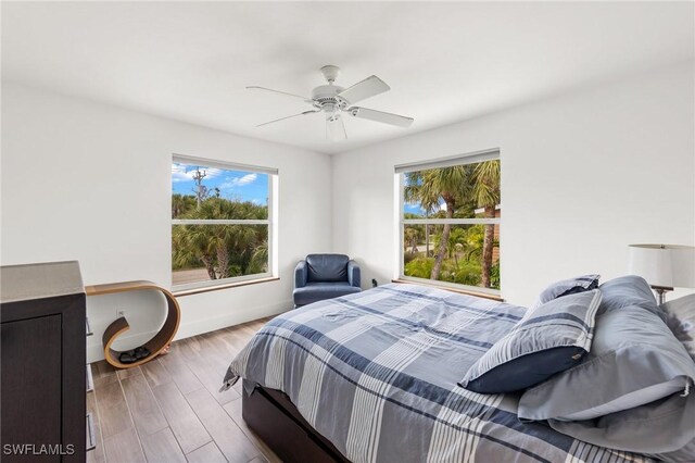 838-840 Rabbit Rd, Sanibel, FL 33957 - bedroom featuring baseboards, wood finished floors, ceiling fan, and multiple windows