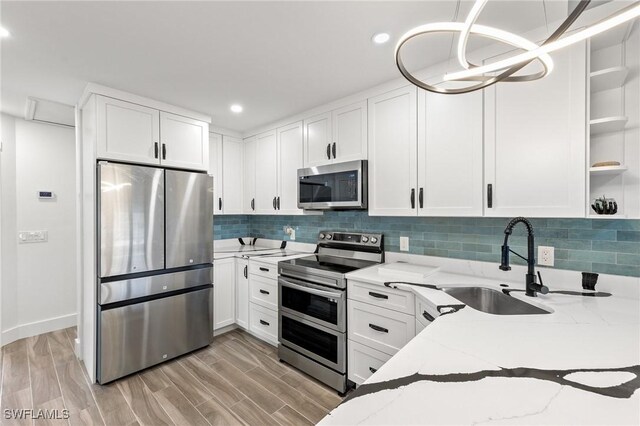 838-840 Rabbit Rd, Sanibel, FL 33957 - kitchen featuring light stone counters, white cabinetry, open shelves, a sink, and appliances with stainless steel finishes