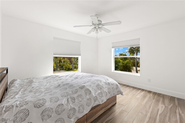 838-840 Rabbit Rd, Sanibel, FL 33957 - bedroom featuring wood finished floors, baseboards, a ceiling fan, and multiple windows