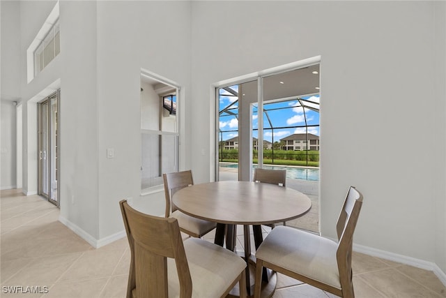 dining room with light tile patterned flooring and a high ceiling