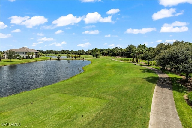 surrounding community with a water view and a lawn