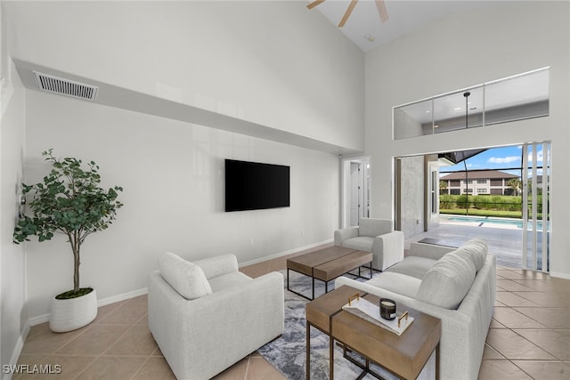 living room with light tile patterned floors, a high ceiling, and ceiling fan