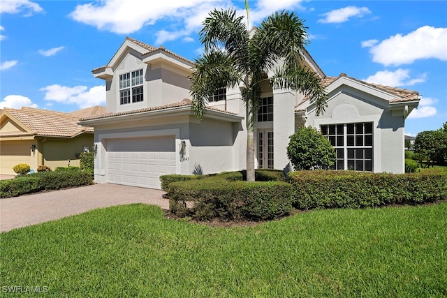 mediterranean / spanish house featuring a front yard and a garage